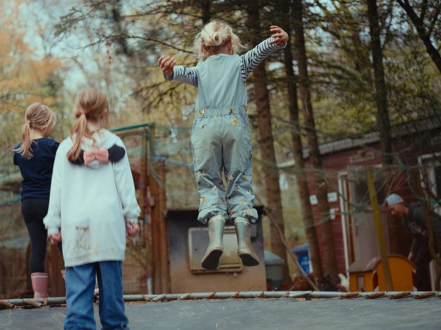 Kinder springen auf dem Trampolin beim Geburtstag auf der Flauschfarm